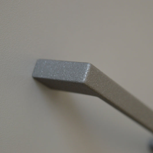 Metal furniture handle, anthracite gray color, with a unique textured surface