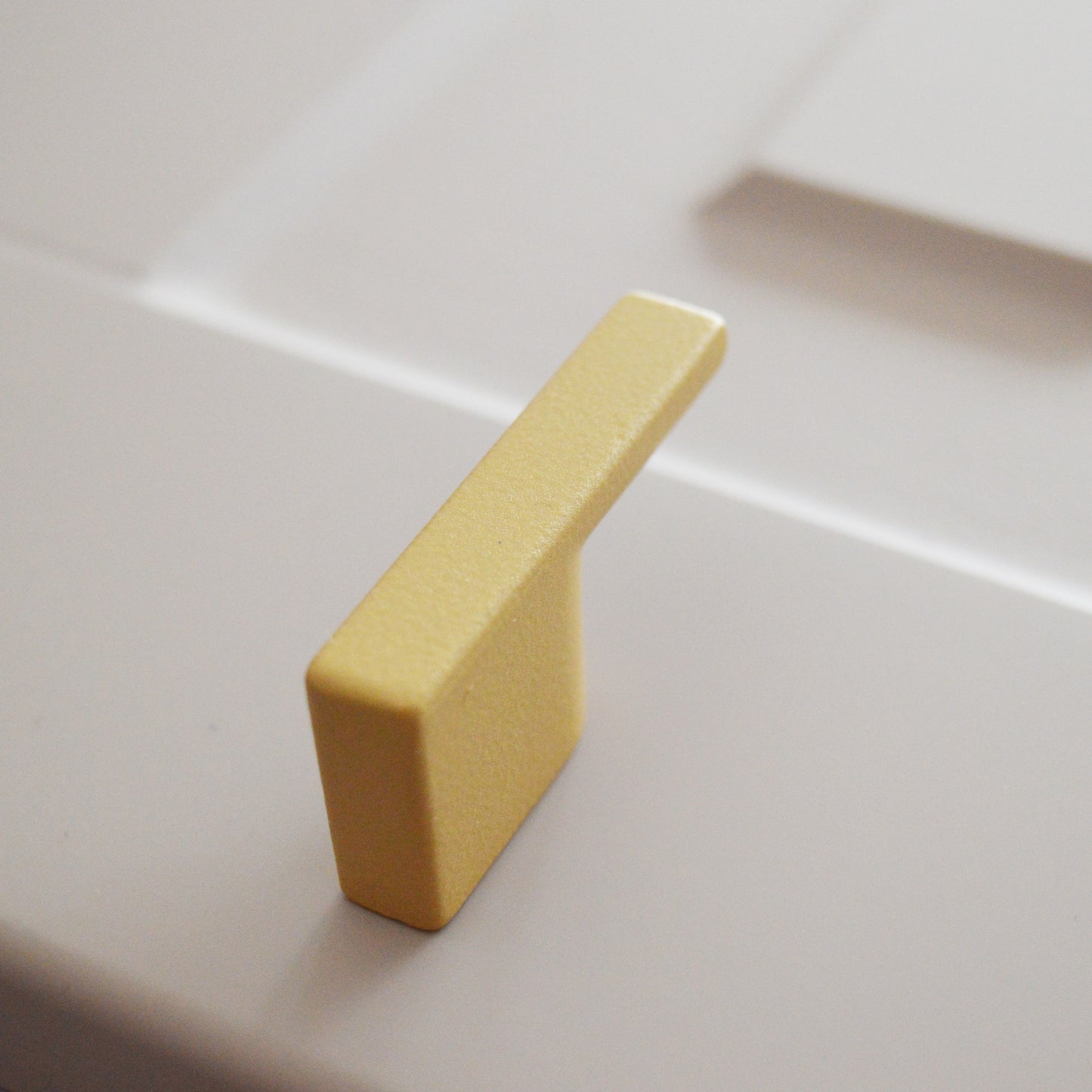 Metal furniture handle, matt gold color, with a unique textured surface