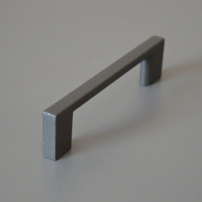 Metal furniture handle, anthracite gray color, with a unique textured surface