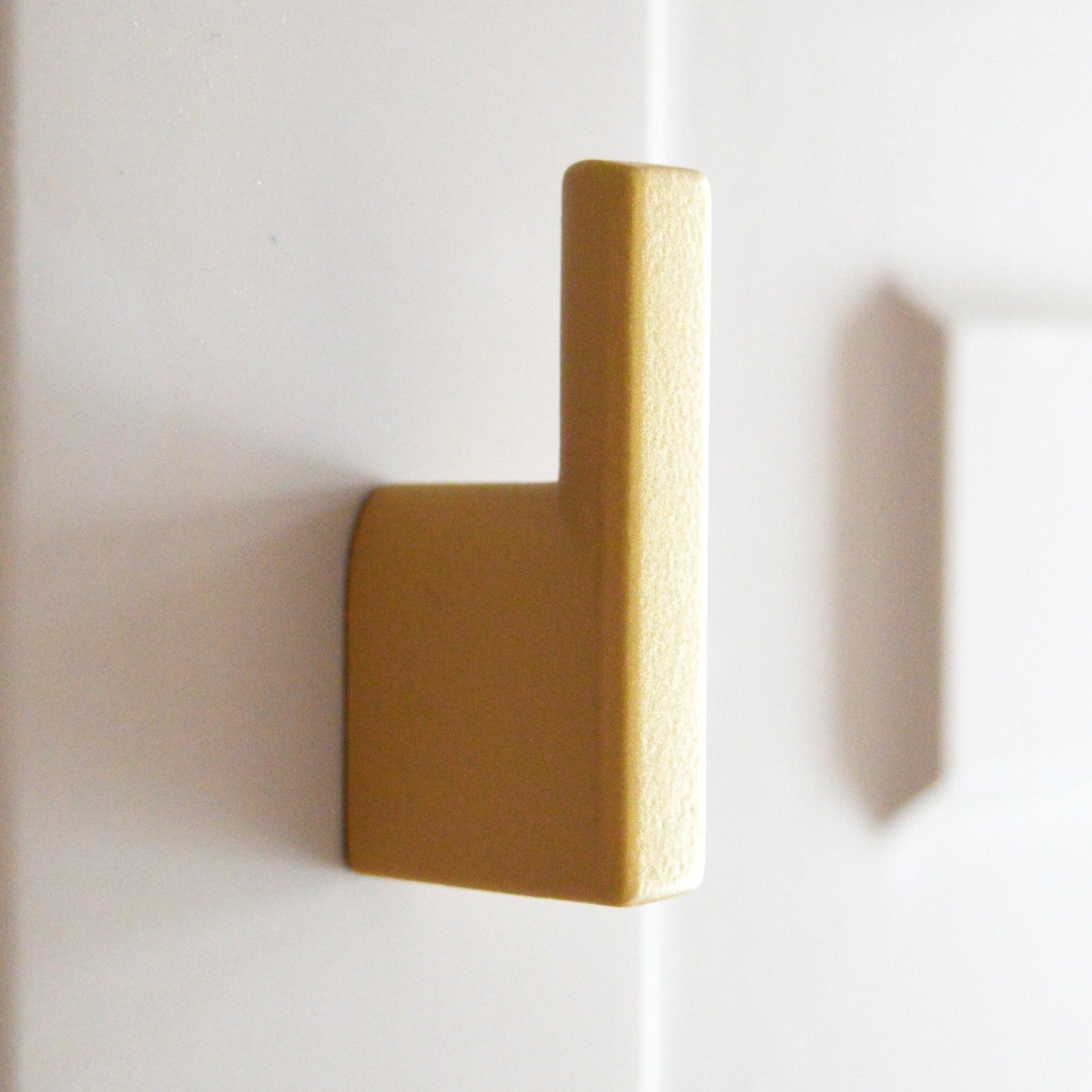 Metal furniture handle, matt gold color, with a unique textured surface