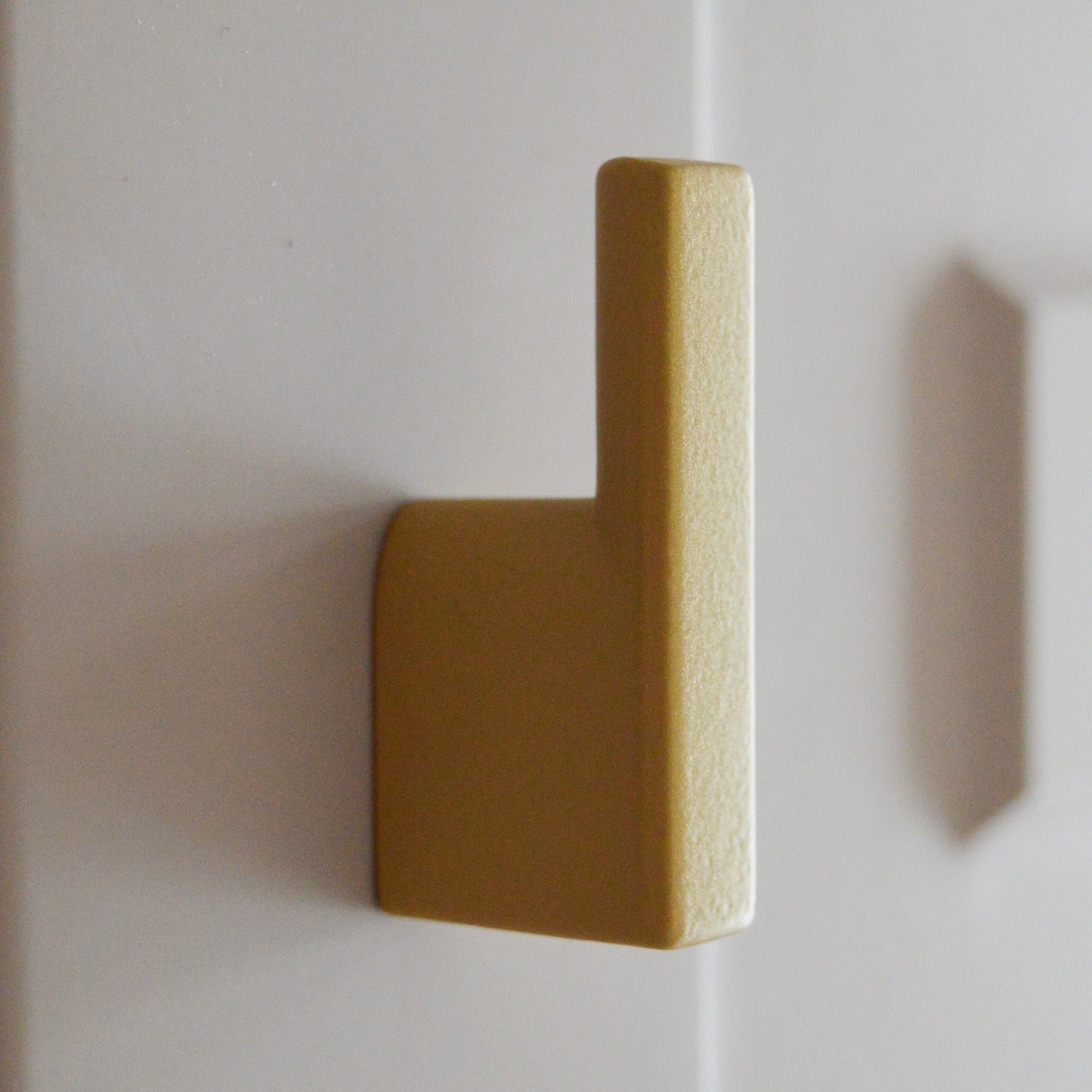 Metal furniture handle, matt gold color, with a unique textured surface