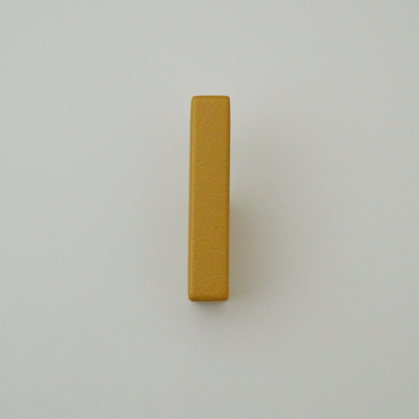 Metal furniture handle, matt gold color, with a unique textured surface