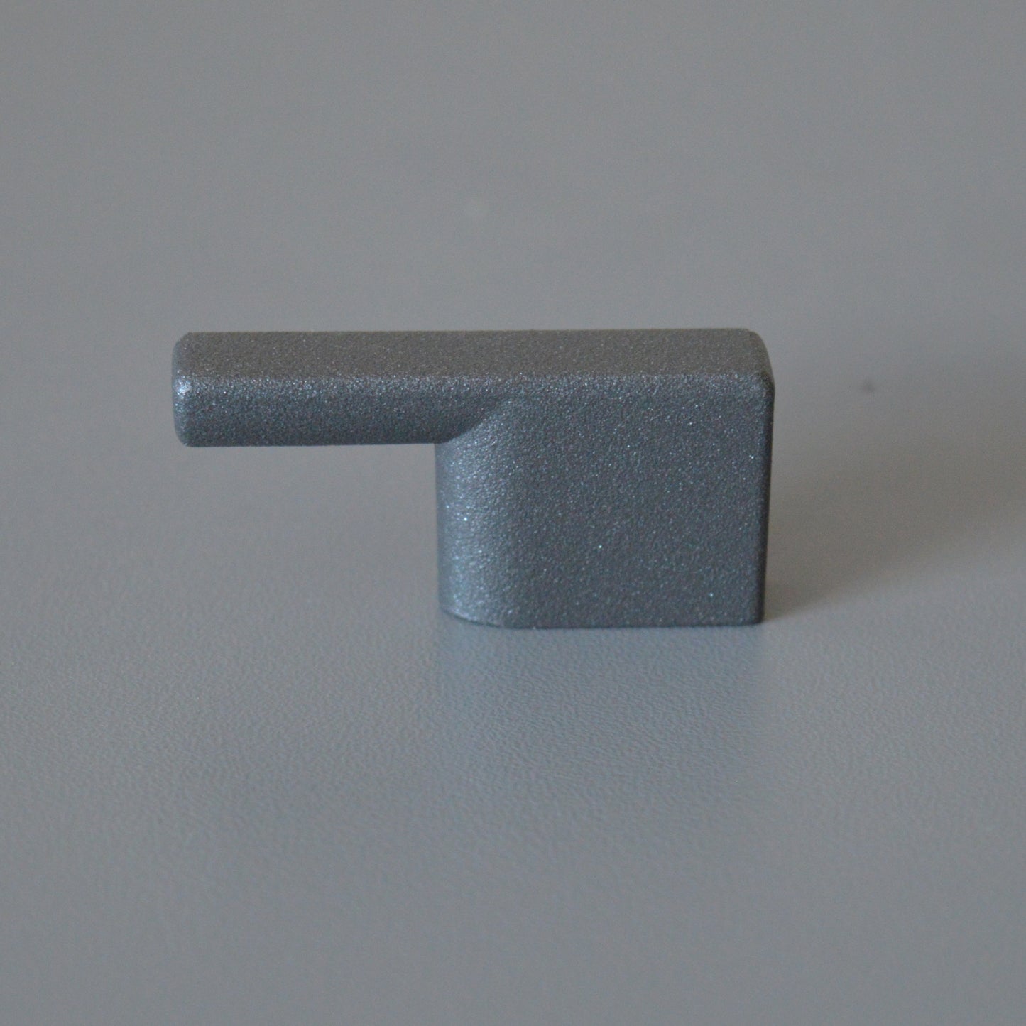 Metal furniture handle, anthracite gray color, with a unique textured surface