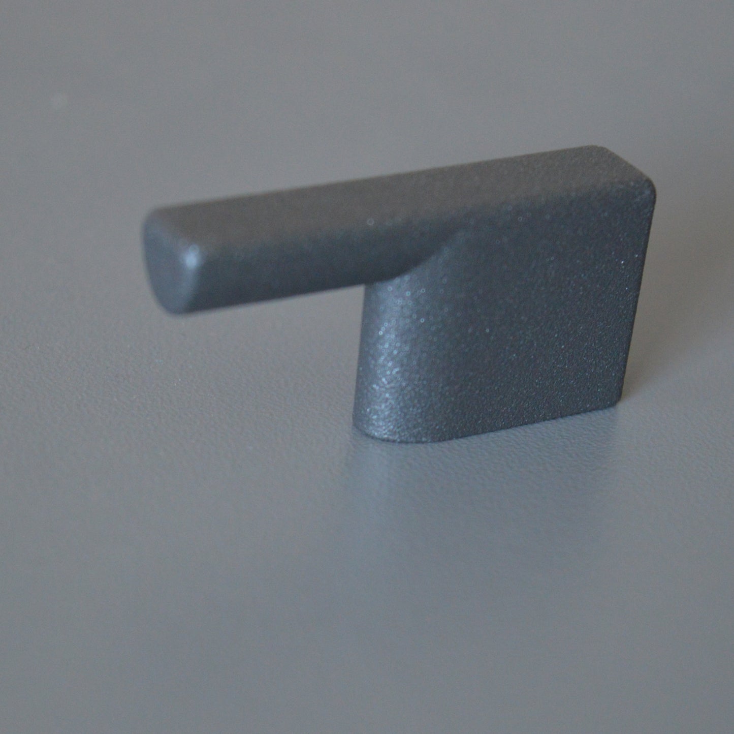 Metal furniture handle, anthracite gray color, with a unique textured surface