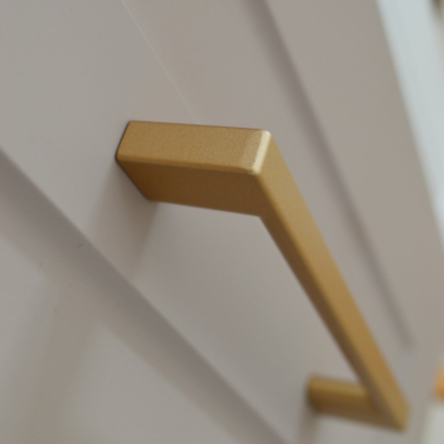 Metal furniture handle, matt gold color, with a unique textured surface